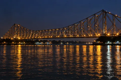 Howrah Bridge lit up at night over the Hooghly river